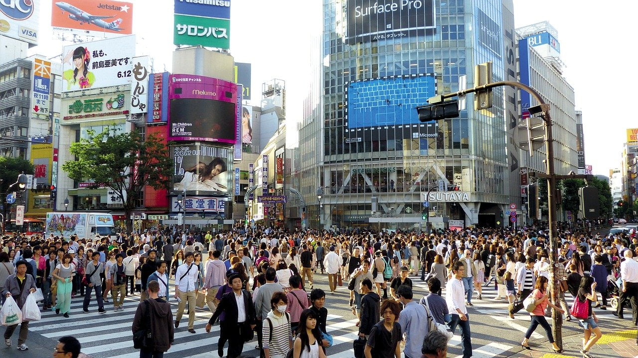 Eine Kreuzung in Shibuya, Tokyo, die von vielen Menschen überquert wird, die von Gott hören, weil Gott spricht