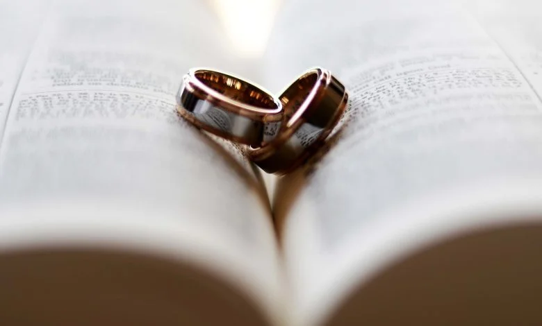 Two wedding rings lying on an open Bible symbolizing faithfulness and not adultery