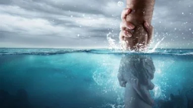 Eine Hand, die eine andere aus dem Wasser rettet, symbolisch für die Taufe mit Wasser in der Bibel